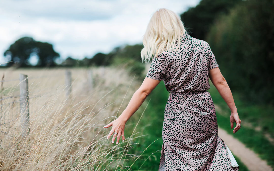 eco friendly and conscious business woman outdoors walking through a field in Fareham