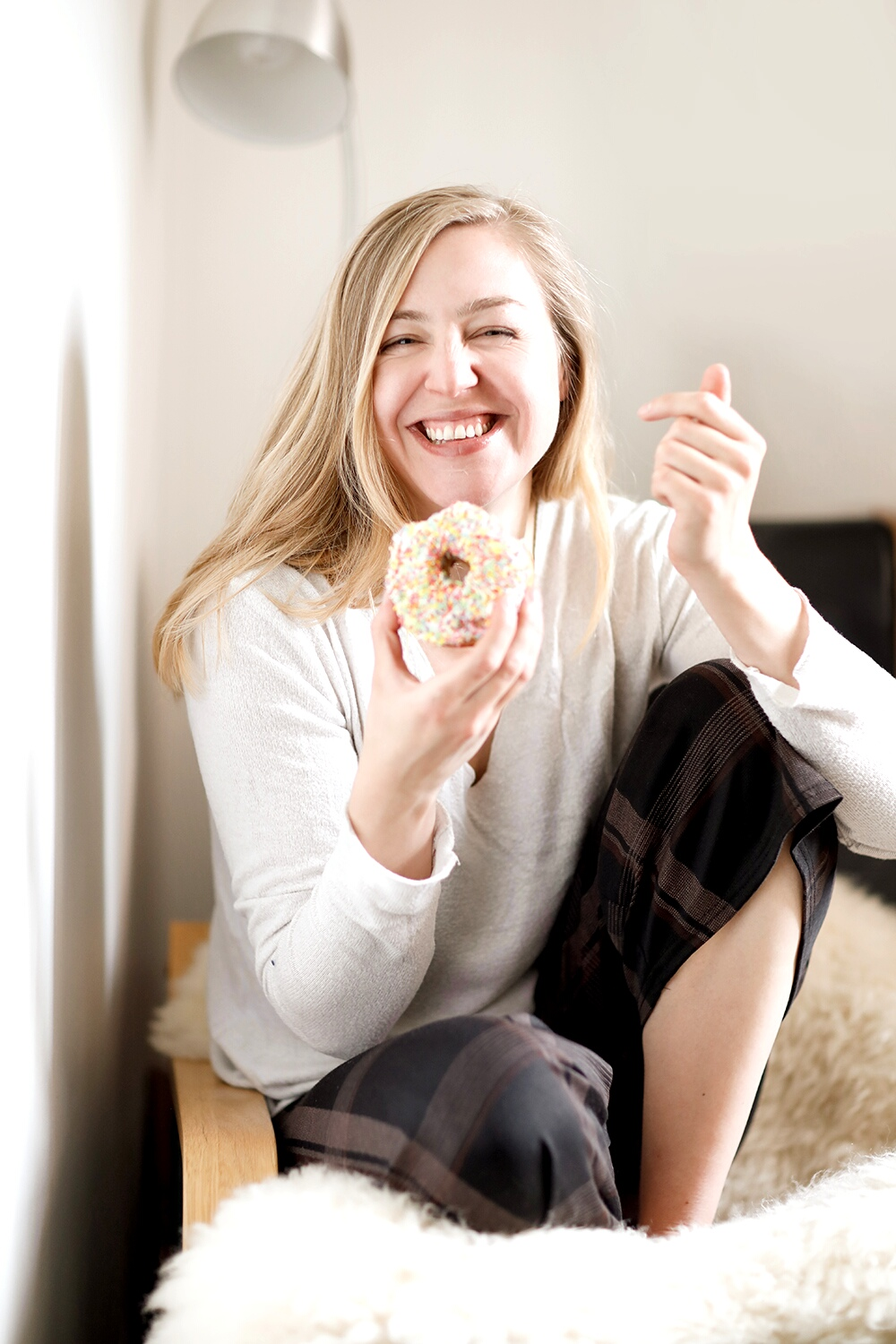 Nadja Litau Photography with doughnut on couch relaxed, smiling, looking in camera